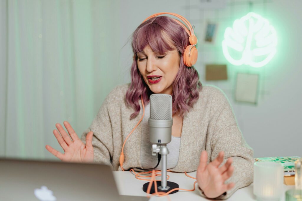 Femme en train d’enregistrer une capsule audio avec un micro et un casque, illustrant le storytelling vocal.