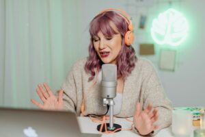 Femme en train d’enregistrer une capsule audio avec un micro et un casque, illustrant le storytelling vocal.