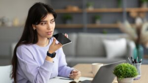 Jeune femme au travail faisant des recherches vocales