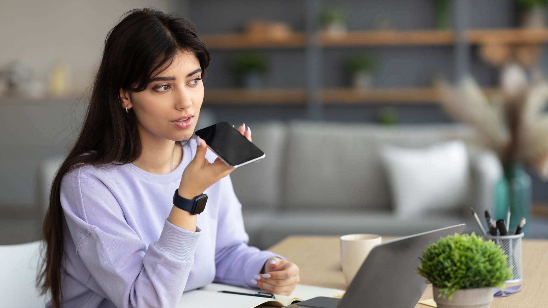 Jeune femme au travail faisant des recherches vocales